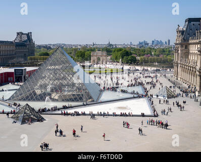 Louvre-Pyramide und Paris über. Die große Glaspyramide im Innenhof des Louvre-Palast mit Fräsen Touristen & Stadtbild Stockfoto