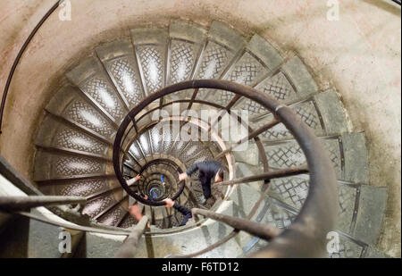 Sie blickte der Wendeltreppe auf den Bogen. Die geschwungene Wendeltreppe, die unten von der Oberseite des Arc de Triomphe führt Stockfoto