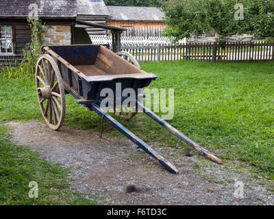 Ochsenkarren geparkt für den Abend. Eine blaue Ochsenkarren parkten hinter einem Haus im Upper Canada Village, morgen einsatzbereit. Stockfoto