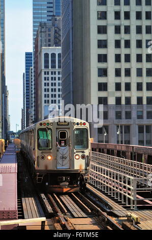 Ein CTA braune Linie Bahn überquert eine Brücke, die über den Chicago River, wie es von Chicagos berühmten Schleife verlässt. Chicago, Illinois, USA. Stockfoto