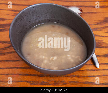 Bohnen Suppe in Keramikschale auf Holztisch Stockfoto