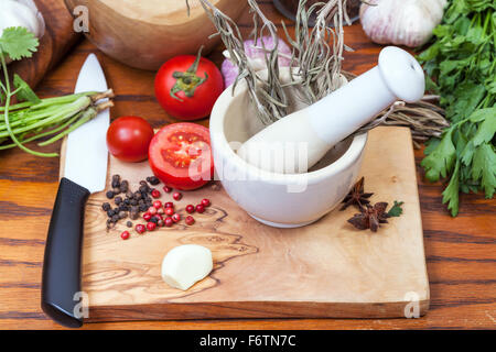 Kochen Gewürze - Keramik Mörser und würzigen Zutaten auf Tisch Stockfoto
