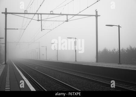 Leere Plattform an einem Bahnhof an einem nebligen Tag im Herbst. Stockfoto