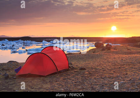 Roten Tunnelzelt bei einem wunderschönen Sonnenaufgang an der Jökulsárlón Lagune auf Island. Stockfoto