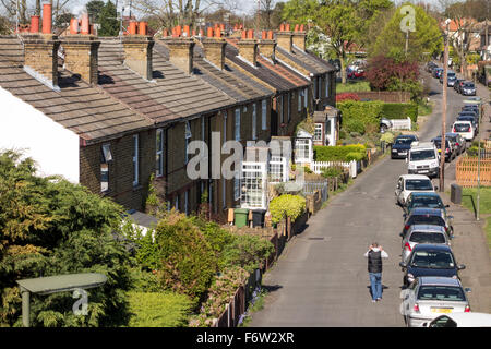 Typische Vorstadt Reihenhäuser und geparkten Autos entlang der Straße, Surrey, UK Stockfoto