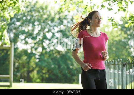 Weibliche Läufer im Park mit Wearable Technology Stockfoto