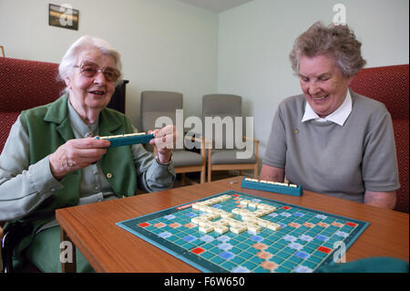 Zwei ältere Frauen spielen Scrabble im Tageszentrum, Stockfoto