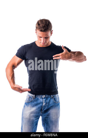 Gut aussehend muskulöse jungen Mann tragen lässige schwarzes Hemd und Jeans zeigt leere Kopie Speicherplatz auf seinem T-Shirt mit Händen beim L darstellen Stockfoto