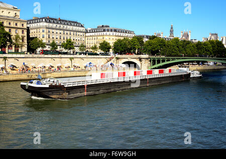 Lastkahn vorbei über die Seine, an den Ufern Menschen den Sommer in Paris verbringen. Stockfoto