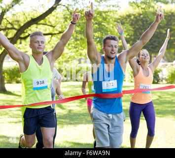 glückliche junge männliche Läufer gewinnen auf Rennen beenden Stockfoto