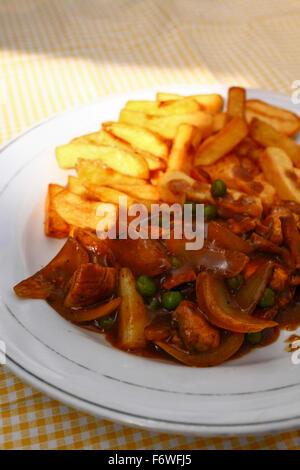 Chicken curry Rühren braten und Chips auf einem gelben überprüft Tischdecke Stockfoto