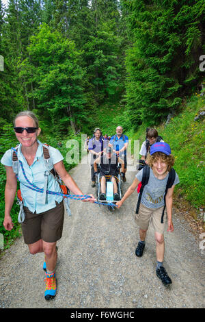 Gruppe von Wanderern, die begleitenden Mann im Rollstuhl, Bergsteigen mit behinderten Menschen, Rotwand, Spitzing, Bayerische Alpen, obere Stockfoto