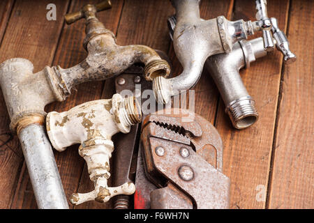 Sanitär-Werkzeuge liegen alte Rohre und Armaturen Stockfoto