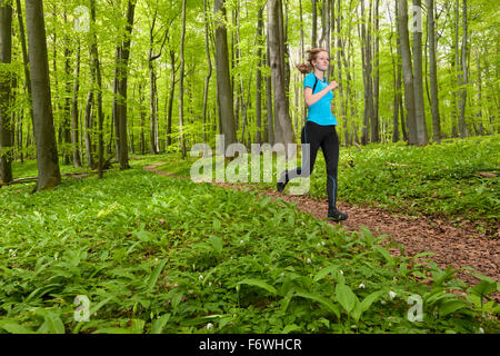 Junge Frau Joggen in einem Buche Wald, Nationalpark Hainich, Thüringen, Deutschland Stockfoto