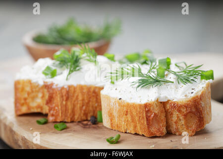 knusprige Baguette Scheiben mit Frischkäse und Kräutern Stockfoto