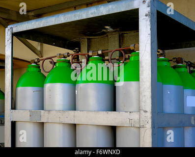 Eine Gruppe von industriellen Gasflaschen, angeordnet in einem Rack auf der Außenseite einer Fabrik Stockfoto