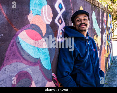 Mann, der bei der bemalten Wand, Township Khayelitsha, Kapstadt, Western Cape, Südafrika Stockfoto