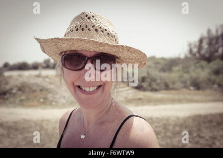 Porträt einer lächelnden Frau trägt einen Strohhut. Stockfoto