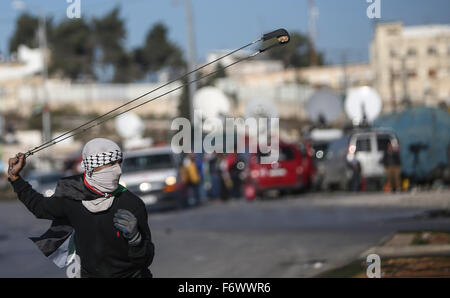 (151120)--RAMALLAH, 20. November 2015 (Xinhua)--A palästinensische Demonstranten eine Schleuder verwendet werfen Steinen auf israelische Soldaten bei Auseinandersetzungen mit zwischen israelischen Soldaten und palästinensische Demonstranten in der Nähe der jüdischen Siedlung Bet-El, in der Nähe von der Westbank Ramallah, 20. November 2015. Eine Welle der Spannung zwischen Palästinensern und Israelis, die Anfang Oktober begann hat sich in gewalttätigen Auseinandersetzungen in den palästinensischen Gebieten verschlechtert. Laut dem palästinensischen Gesundheitsministerium 89 Palästinenser wurden getötet und mehr als 3.000 verwundet, während die israelische Medien sagen 14 Israelis töten Stockfoto