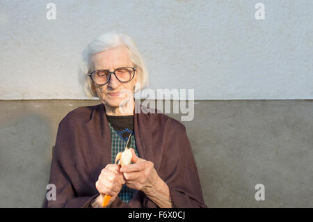 Neunzig Jahre alt Oma schneiden und schälen eines Apfels Stockfoto