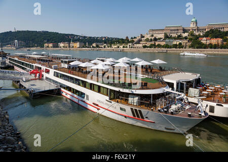 Genuss-Cruiser festgemacht an der Donau gegenüber Buda Schloss und Burgberg in Budapest, Ungarn. Stockfoto