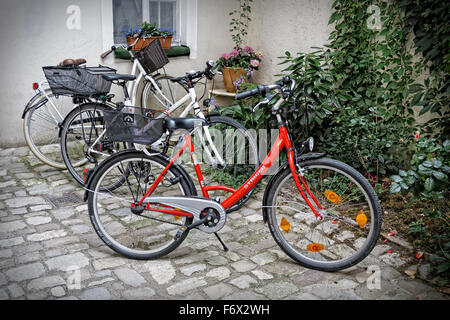 Geparkte Fahrräder auf gepflasterten Seitenstraße in Regensburg, Deutschland. Stockfoto