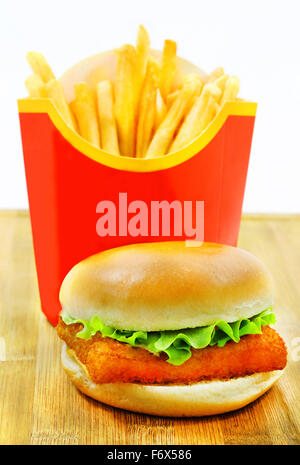 Burger mit Pommes und Fisch ist fotografierten Nahaufnahme auf einem Holzbrett Stockfoto