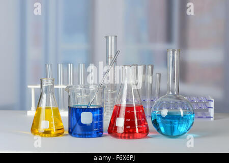 Labortisch mit Glaswaren mit Flüssigkeiten in verschiedenen Farben Stockfoto