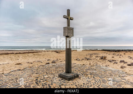 Dichtung mit Robben (Pinnipedia) in den Hintergrund und die Nachbildung des Cape Cross, ein Grab Marker für ein portugiesischer Entdecker, Diogoco reservieren Stockfoto