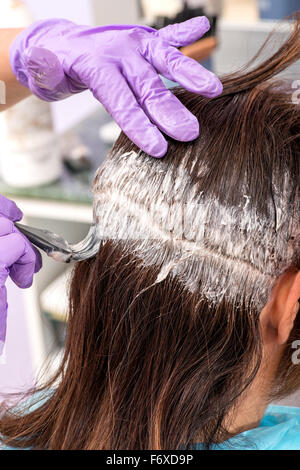 Friseur einen Kunden Haarwurzeln Farbton mit einem kleinen Applikator Pinsel zuweisen Stockfoto