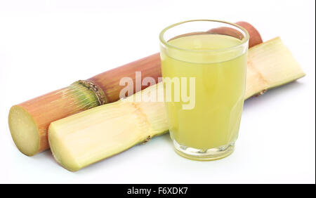 Stücke von Zuckerrohrsaft in einem Glas auf weißem Hintergrund Stockfoto