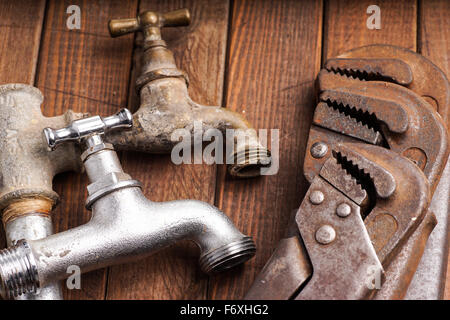 Sanitär-Werkzeuge liegen alte Rohre und Armaturen Stockfoto