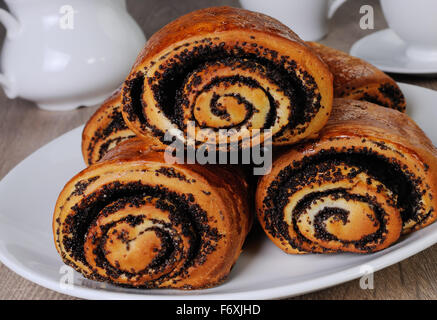 Frisch gebackene Brötchen mit Mohn auf einem Teller Stockfoto