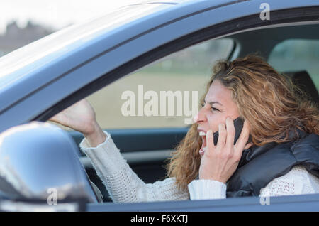 Frau ist ihr Auto sehr aggressiv und ein Gespräch Stockfoto