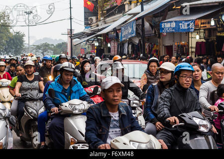 HANOI - 17. Februar 2015: Viele Roller fahren in den kleinen Gassen der Altstadt in Hanoi, Vietnam. Am nächste Tag ist ein Feiertag für die bekommen die Einheimischen Lebensmittel und andere Sachen, so gibt es eine Menge Verkehr passiert heute. Stockfoto