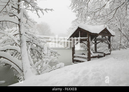 Central Park ruhige Winterlandschaft nach starkem Schneefall. Die Bogen-Brücke und einem Pavillon aus Holz sind mit Schnee bedeckt. New York City Stockfoto