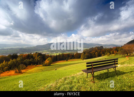 Sonniger Herbst Alpenpanorama mit schöner Aussicht und mit einer Bank für Rest im Vordergrund Stockfoto