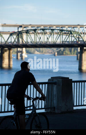 Ein Radfahrer Fahrrad entlang der Uferpromenade in Portland, Oregon. Stockfoto