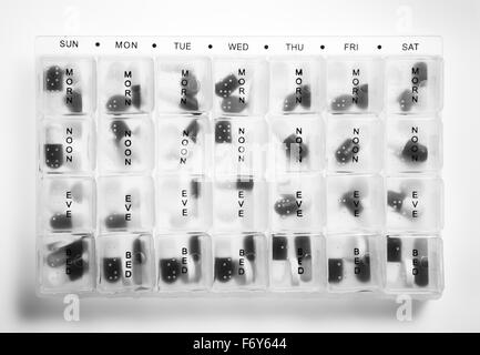 volle Behälter Pillenbox zeigt die Wochentage und Zeiten, so dass Sie wissen, was Pillen um zu nehmen, und wenn Stockfoto