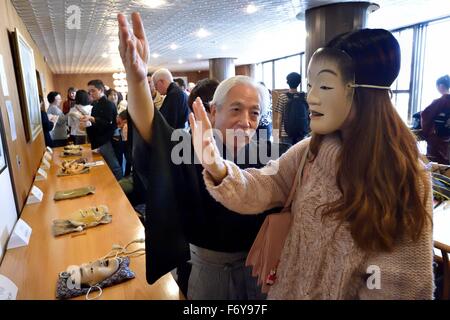 Tokio, Japan. 20. November 2015. Ein beispielloses Ereignis, das japanischen Noh Theater für ein internationales Publikum öffnen soll können "Experience Corner" Publikum Mitglieder Don Masken und Kostüme während vom Meister Lehrer geführt. Das Ereignis '' Noh-Theater: jenseits der Worte, über Grenzen hinaus '' bietet Auswahl an Noh in Japanisch und Engish Publikum eine Chance zu vergleichen wie Noh Power Transcendsanguage Barrieren. Moderiert wurde die Veranstaltung von Art Rat Tokyo und der Kita Schule Noh Theater Nohgaku im Roppeita XIV Commemorative Noh Theater in Tokio, Japan © ZUMA Press, Inc./Alamy Stockfoto