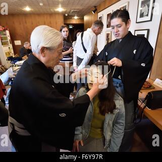 Tokio, Japan. 20. November 2015. Ein beispielloses Ereignis, das japanischen Noh Theater für ein internationales Publikum öffnen soll können "Experience Corner" Publikum Mitglieder Don Masken und Kostüme während vom Meister Lehrer geführt. Das Ereignis '' Noh-Theater: jenseits der Worte, über Grenzen hinaus '' bietet Auswahl an Noh in Japanisch und Engish Publikum eine Chance zu vergleichen wie Noh Power Transcendsanguage Barrieren. Moderiert wurde die Veranstaltung von Art Rat Tokyo und der Kita Schule Noh Theater Nohgaku im Roppeita XIV Commemorative Noh Theater in Tokio, Japan © ZUMA Press, Inc./Alamy Stockfoto