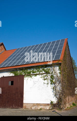 Alte Scheune mit Solarzellen auf dem Dach Stockfoto