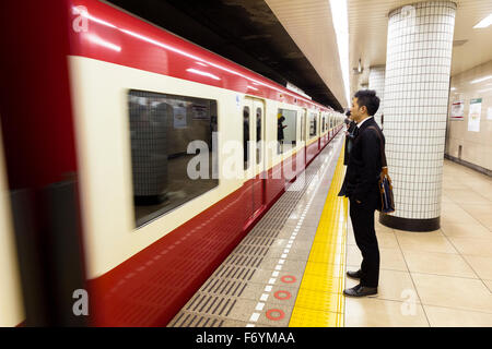 Ein Japaner im Untergrund für einen vorbeifahrenden Zug warten Stockfoto