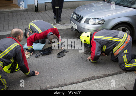 Feuerwehrleute kommen, einen silbernen Audi aufgespießt auf automatische steigende Poller in Castle Street, Falmouth zu entfernen. 1. November 2015. Stockfoto