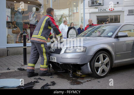 Feuerwehrleute kommen, einen silbernen Audi aufgespießt auf automatische steigende Poller in Castle Street, Falmouth zu entfernen. 1. November 2015. Stockfoto