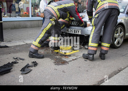 Feuerwehrleute kommen, einen silbernen Audi aufgespießt auf automatische steigende Poller in Castle Street, Falmouth zu entfernen. 1. November 2015. Stockfoto