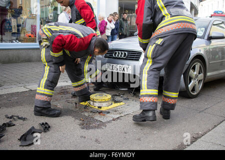 Feuerwehrleute kommen, einen silbernen Audi aufgespießt auf automatische steigende Poller in Castle Street, Falmouth zu entfernen. 1. November 2015. Stockfoto