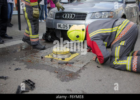 Feuerwehrleute kommen, einen silbernen Audi aufgespießt auf automatische steigende Poller in Castle Street, Falmouth zu entfernen. 1. November 2015. Stockfoto