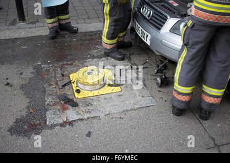 Feuerwehrleute kommen, einen silbernen Audi aufgespießt auf automatische steigende Poller in Castle Street, Falmouth zu entfernen. 1. November 2015. Stockfoto