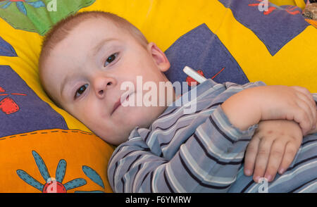 Kranken kleinen Jungen im Bett. Messung der Temperatur Stockfoto